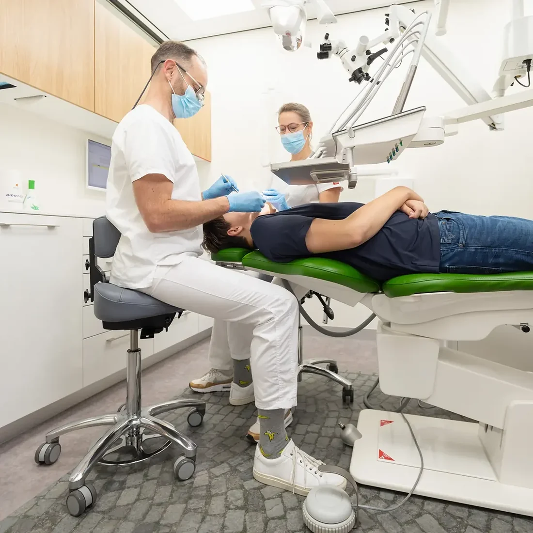 Tandarts en assistente op BQE-zadelkrukken met rugsteun aan de behandelunit